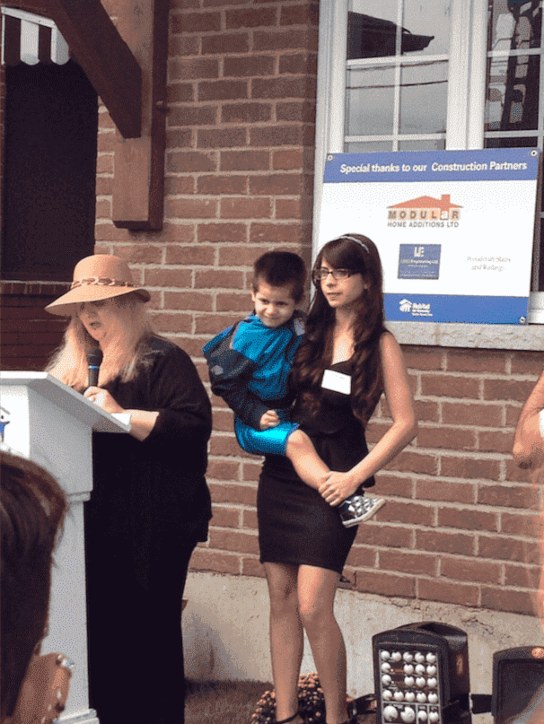 A Woman Carrying a Boy During Costa Family Move-in Day in Toronto