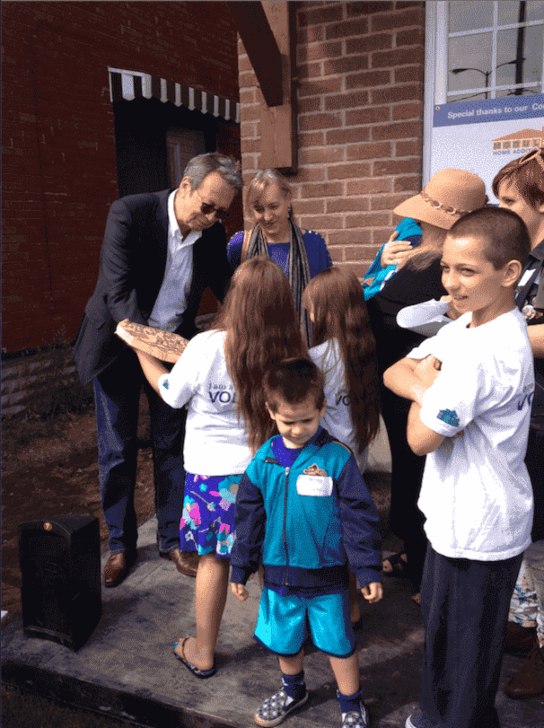 A Couple Distributing Goodies to Kids at Costa Family Move-in Day in Toronto